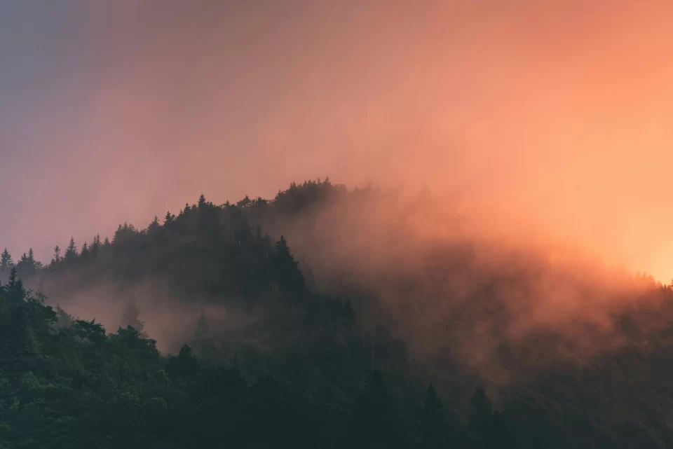 A pink cloud or hazy fog over mountains.